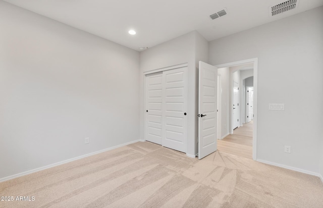 unfurnished bedroom featuring arched walkways, baseboards, visible vents, and light colored carpet