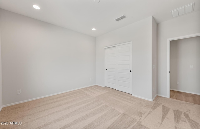 unfurnished bedroom with baseboards, visible vents, light colored carpet, and recessed lighting