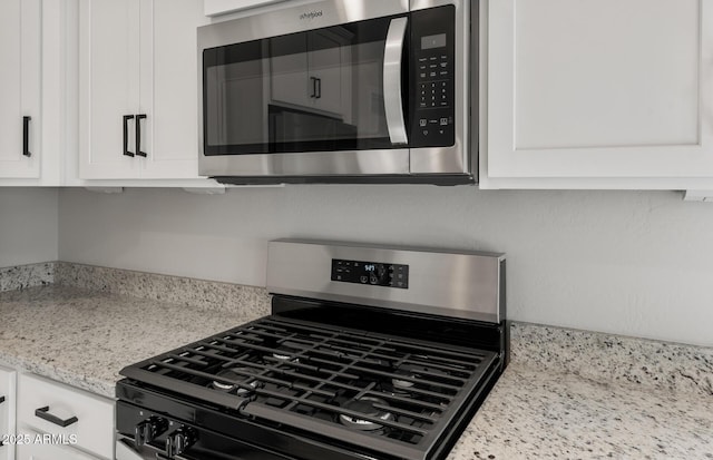 kitchen featuring white cabinets, light stone countertops, and stainless steel appliances