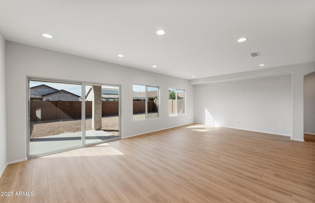 unfurnished living room featuring light wood-type flooring, visible vents, baseboards, and recessed lighting