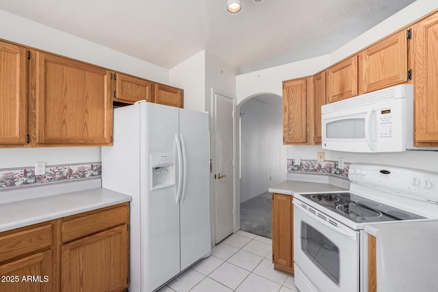 3349 E Lavey Ln, Phoenix, AZ 85032 - kitchen featuring light tile patterned floors, white appliances, arched walkways, vaulted ceiling, and light countertops