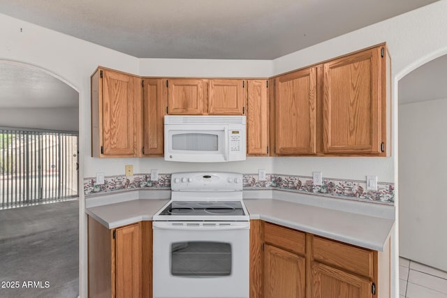 3349 E Lavey Ln, Phoenix, AZ 85032 - kitchen with arched walkways, light countertops, and white appliances