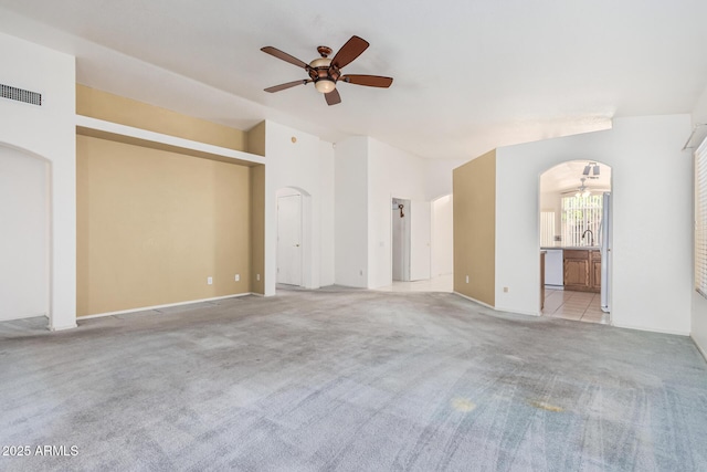 3349 E Lavey Ln, Phoenix, AZ 85032 - unfurnished living room with arched walkways, a ceiling fan, visible vents, carpet floors, and lofted ceiling