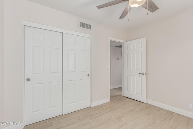 unfurnished bedroom with light hardwood / wood-style floors, ceiling fan, and a closet