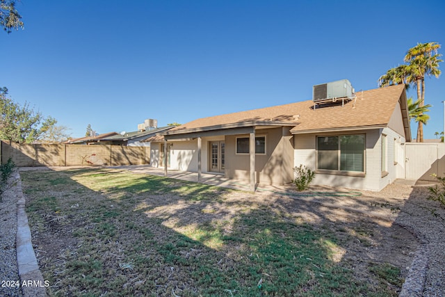 rear view of house with a yard, cooling unit, and a patio area