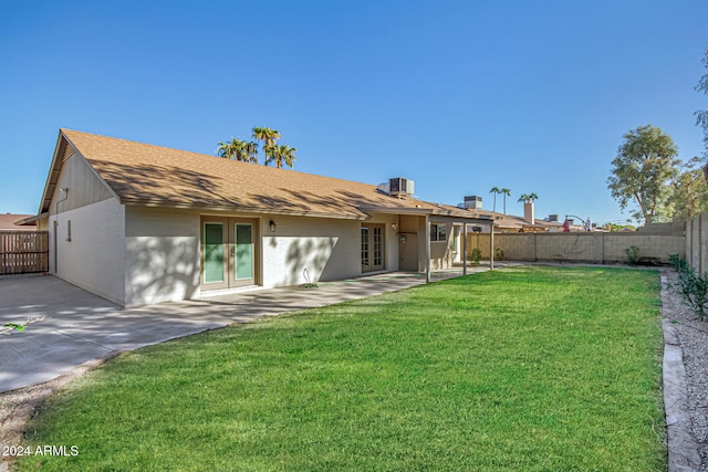 rear view of property with central AC, a yard, french doors, and a patio area