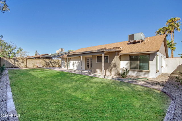 rear view of property with central AC unit, a yard, and a patio