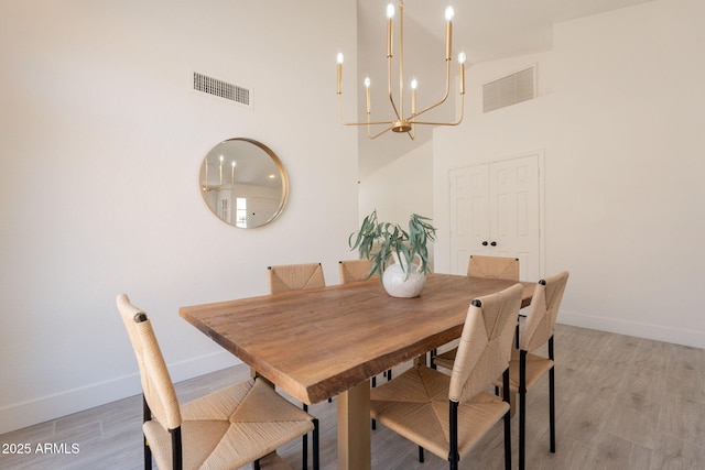 4037 E Milton Dr, Cave Creek, AZ 85331 - dining room featuring a chandelier, a towering ceiling, and light wood-style floors