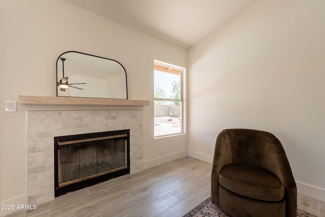 4037 E Milton Dr, Cave Creek, AZ 85331 - living area featuring a tiled fireplace, wood finished floors, and ceiling fan
