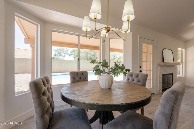 4037 E Milton Dr, Cave Creek, AZ 85331 - dining area featuring a chandelier, light wood-style flooring, and a tile fireplace