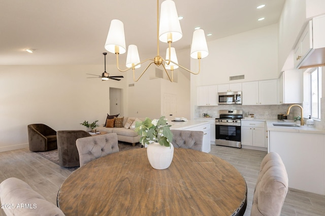 4037 E Milton Dr, Cave Creek, AZ 85331 - dining space featuring a chandelier, light wood-style flooring, high vaulted ceiling, a ceiling fan, and recessed lighting