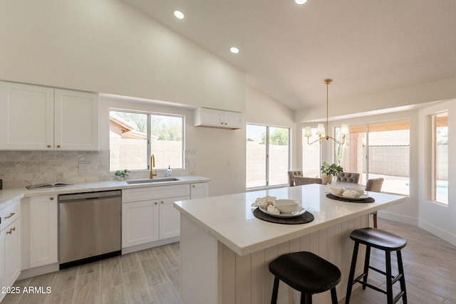 4037 E Milton Dr, Cave Creek, AZ 85331 - kitchen featuring stainless steel dishwasher, a chandelier, decorative backsplash, light wood-style flooring, and white cabinetry