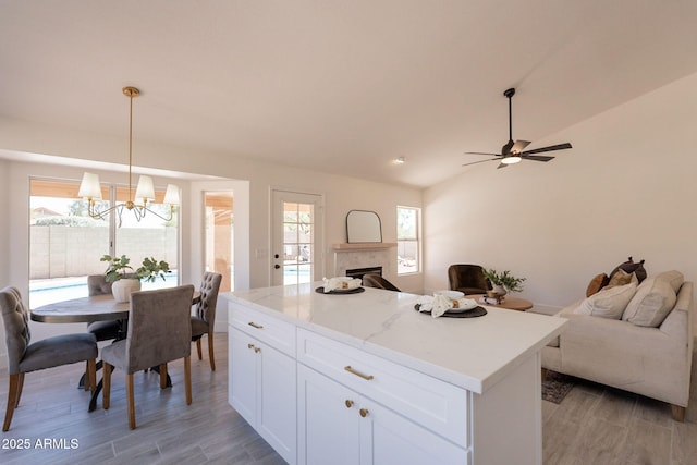 4037 E Milton Dr, Cave Creek, AZ 85331 - kitchen featuring open floor plan, light wood-style floors, a tile fireplace, a chandelier, and lofted ceiling