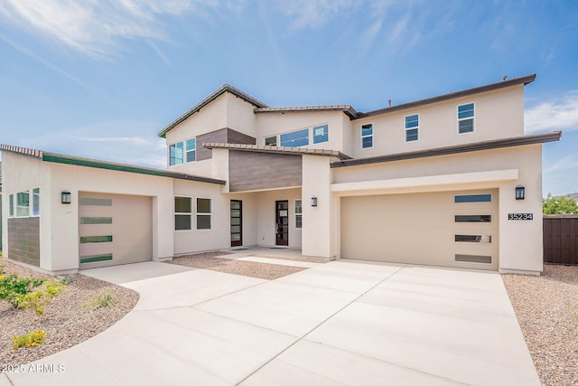 modern home featuring concrete driveway, an attached garage, and stucco siding