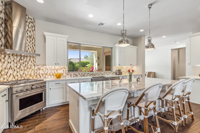 625 W Echo Ln, Phoenix, AZ 85021 - kitchen with white cabinets, high end stove, dark wood-style floors, wall chimney exhaust hood, and backsplash