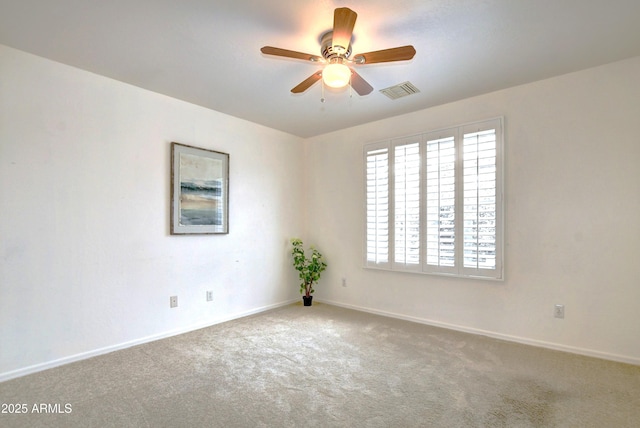 empty room featuring ceiling fan and carpet