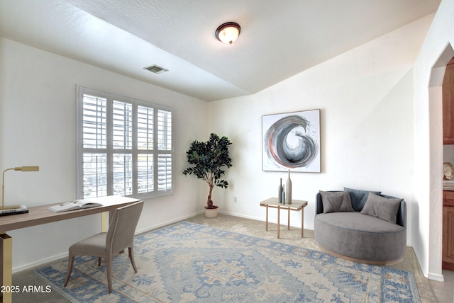 carpeted office with lofted ceiling