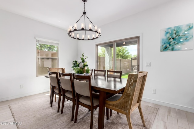 8640 W Frier Dr, Glendale, AZ 85305 - dining space featuring a chandelier, light wood finished floors, and baseboards
