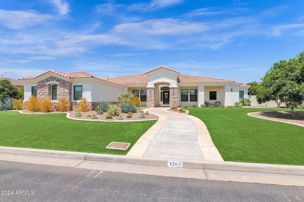 mediterranean / spanish house featuring a front yard