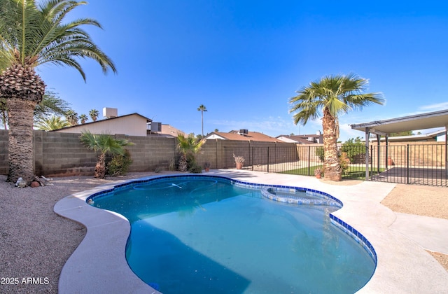 view of swimming pool featuring a pool with connected hot tub and a fenced backyard