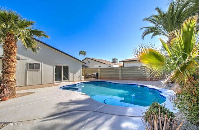 view of pool featuring a pool with connected hot tub, a fenced backyard, and a patio area