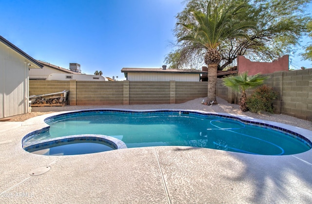 view of pool with a fenced backyard and a pool with connected hot tub