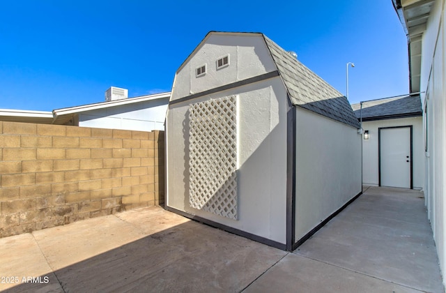view of outbuilding featuring fence