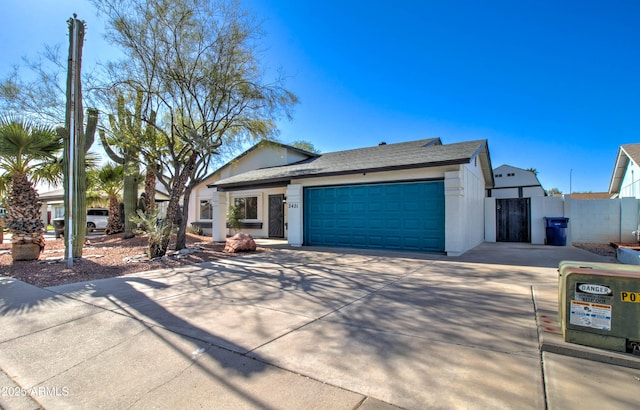 ranch-style house with fence, an attached garage, concrete driveway, and stucco siding