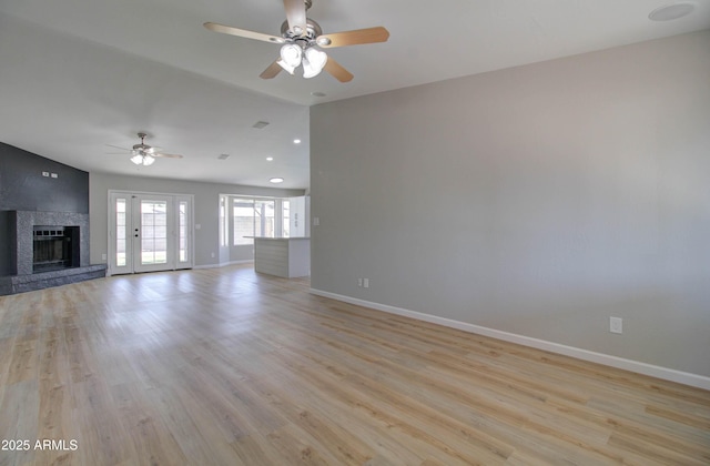 unfurnished living room featuring baseboards, ceiling fan, lofted ceiling, and a large fireplace