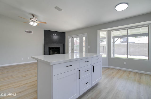 kitchen featuring light countertops, baseboards, light wood-type flooring, and visible vents
