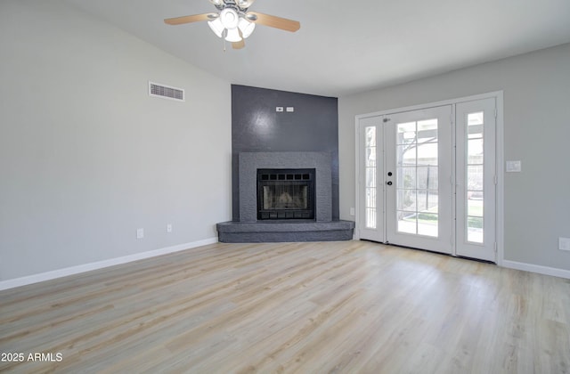 unfurnished living room featuring ceiling fan, visible vents, a large fireplace, wood finished floors, and baseboards