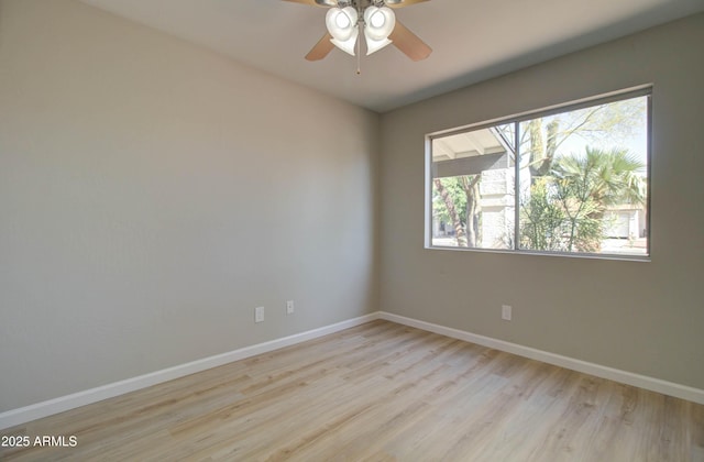 spare room featuring baseboards, ceiling fan, and wood finished floors
