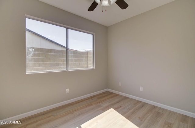 spare room featuring baseboards, ceiling fan, and wood finished floors