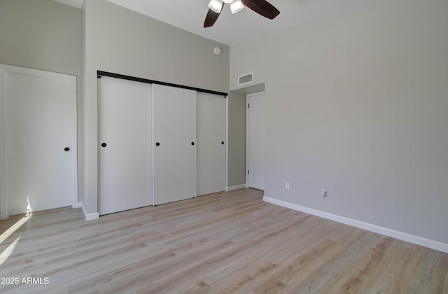 unfurnished bedroom with visible vents, light wood-style flooring, baseboards, and a closet