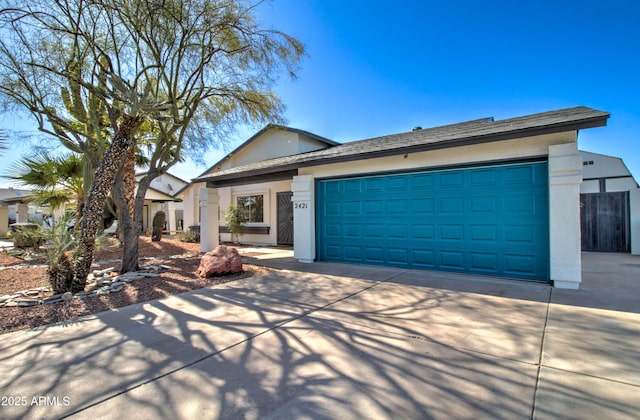 single story home featuring a garage, stucco siding, and driveway