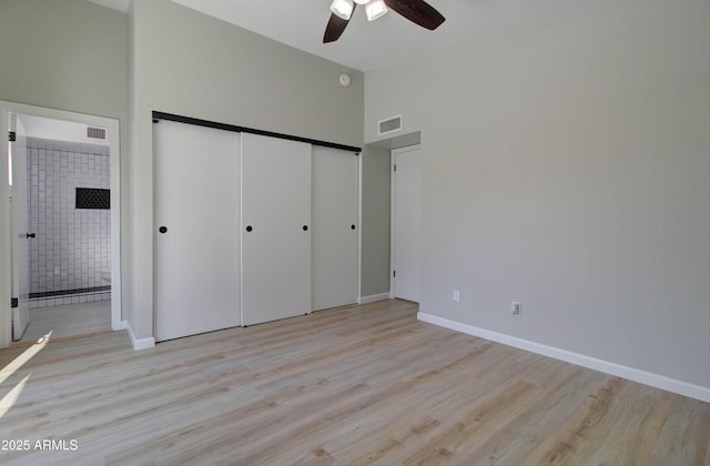 unfurnished bedroom with visible vents, a closet, baseboards, light wood-type flooring, and ensuite bath