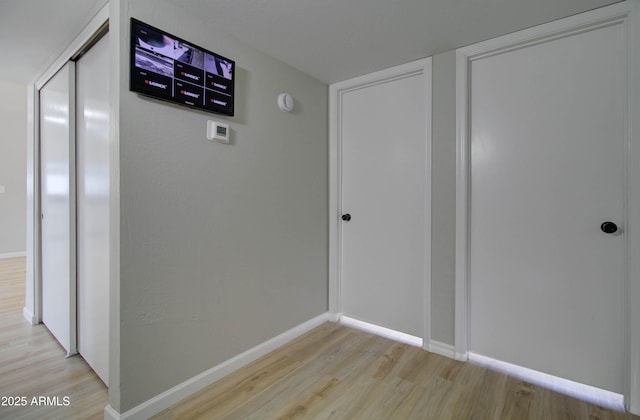 hallway with baseboards and light wood-style flooring
