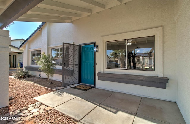 entrance to property featuring stucco siding