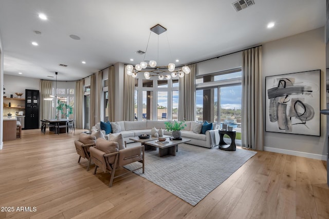 living area featuring a notable chandelier, visible vents, light wood-style flooring, and recessed lighting