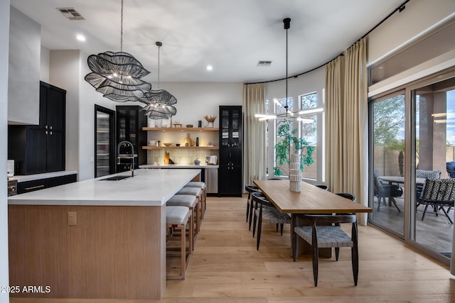 kitchen with an inviting chandelier, light countertops, light wood-type flooring, and a sink