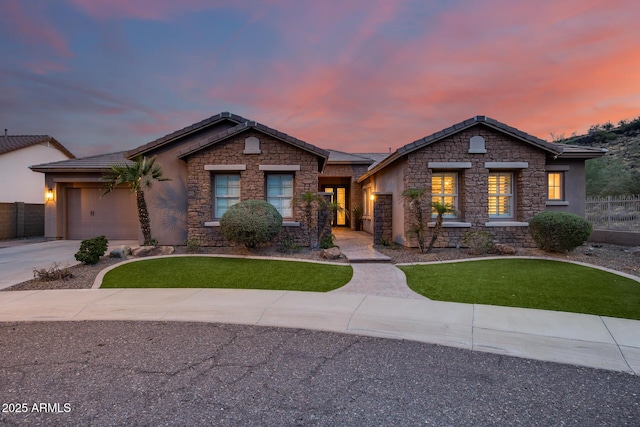 view of front of house with stone siding, an attached garage, concrete driveway, and fence