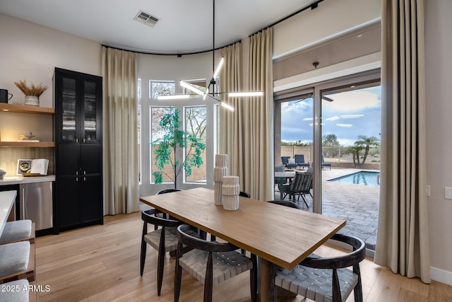 dining room featuring light wood-style flooring and visible vents