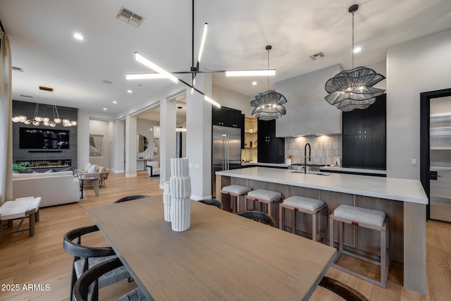 dining area with an inviting chandelier, light wood-style flooring, recessed lighting, and visible vents