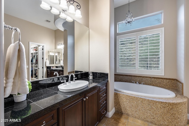 full bathroom featuring vanity, a garden tub, visible vents, and a chandelier