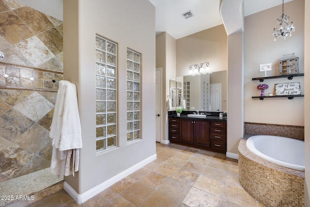 full bathroom featuring visible vents, baseboards, walk in shower, a bath, and vanity