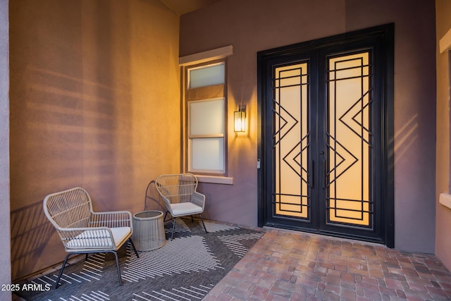 view of exterior entry with french doors and stucco siding