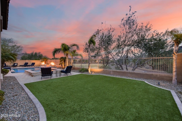 yard at dusk featuring a patio area, a fenced in pool, a fire pit, and a fenced backyard