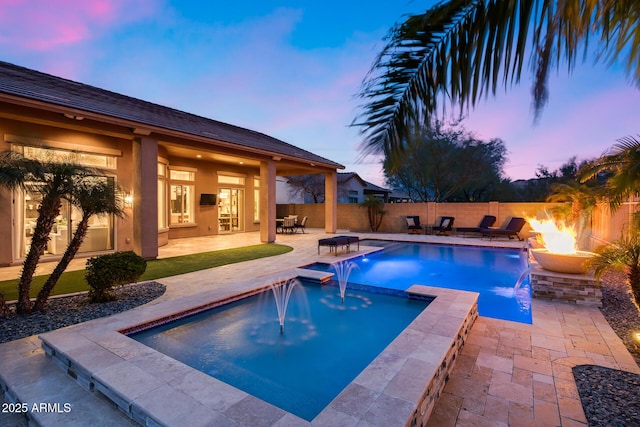 view of swimming pool featuring a patio, a fire pit, a pool with connected hot tub, and fence