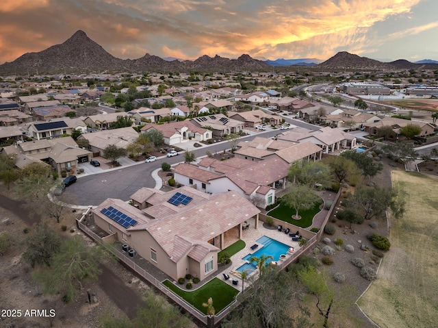 aerial view at dusk featuring a mountain view and a residential view