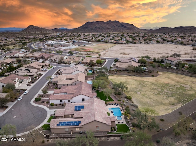 aerial view at dusk featuring a residential view and a mountain view